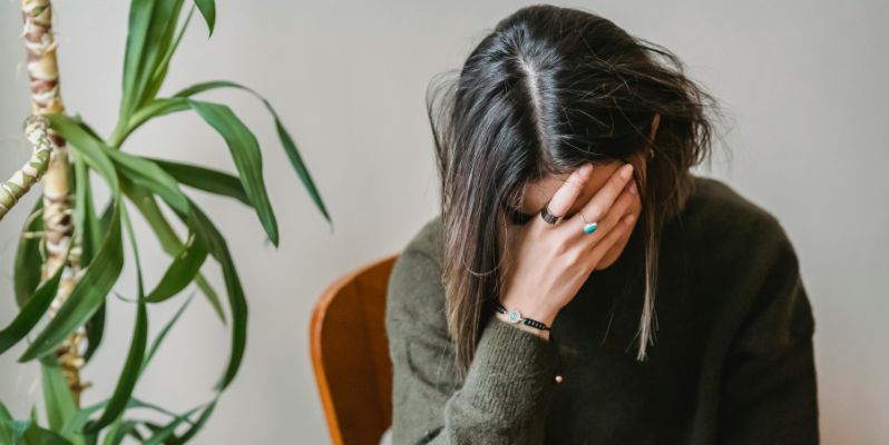Worried young woman covering face with hand
